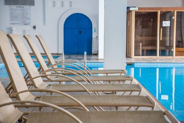 Reihe von Liegestühlen neben dem Pool im Callisto Holiday Village