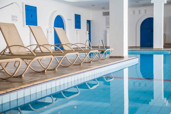 Reihe von Liegestühlen am Pool des Callisto Holiday Village