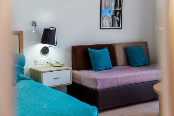 Schlafzimmer mit Bett und Sofa im Callisto Holiday Village