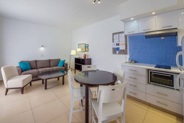 Wohnbereich im Callisto Holiday Village mit Couch, Tisch und Küche.