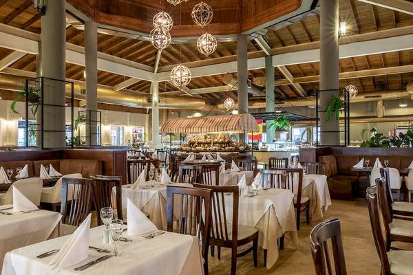 Innenbereich eines Restaurants im Sunscape Coco Punta Cana Hotel mit gedeckten Tischen und Stühlen.