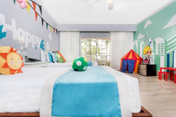 Kinderzimmer im Sunscape Coco Punta Cana Hotel mit bunten Wandmalereien und Spielzeug.
