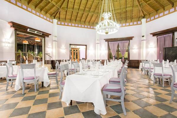 Speisesaal des Sunscape Coco Punta Cana Hotels mit Tischdecken und Deckenleuchten.