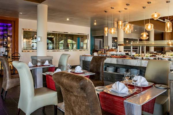 Innenansicht des Restaurants im Sunscape Coco Punta Cana Hotel mit gedeckten Tischen und Buffet.