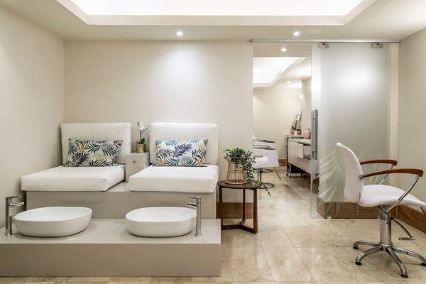 Wellnessbereich im Sunscape Coco Punta Cana Hotel mit zwei Liegen, Waschbecken und einer Tür.