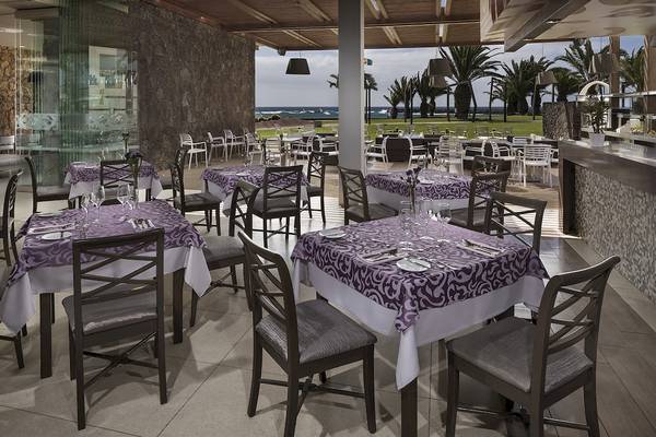 Innenansicht des Restaurants des HD Beach Resort mit Blick auf das Meer und Palmen