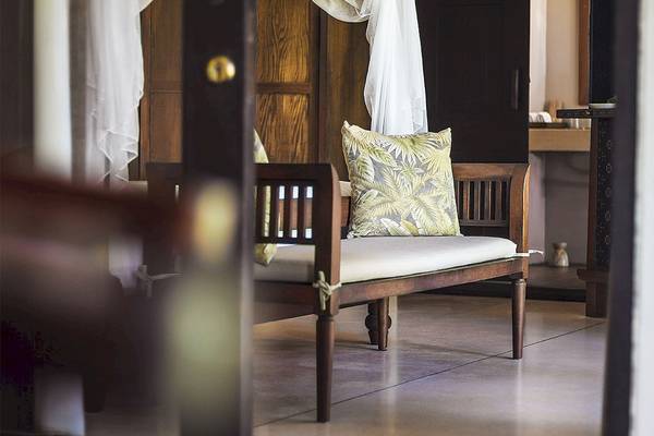 Sitzbank im Saree Samui Resort mit Kissen und Vorhängen.