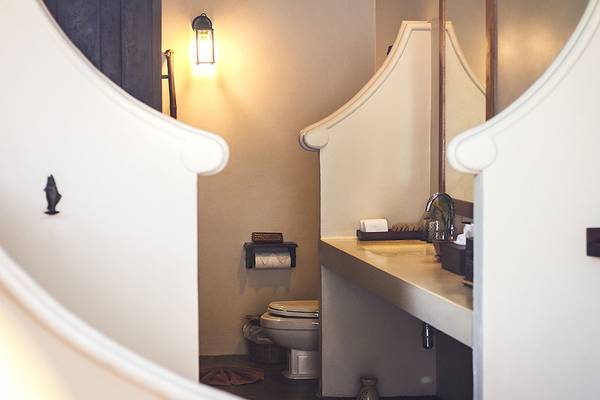 Ein Badezimmer im Saree Samui Resort mit einer Toilette, einem Waschbecken und einer Lampe.