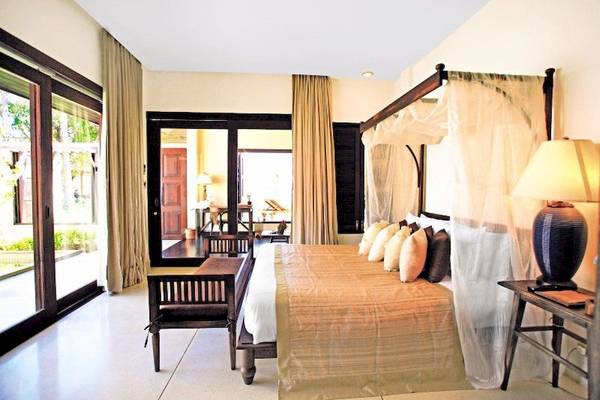 Schlafzimmer im Saree Samui Resort mit einem großen Bett, Nachttischen und einem offenen Balkon.
