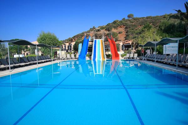 Außenpool des Club Yali Hotels & Resort mit bunten Wasserrutschen.