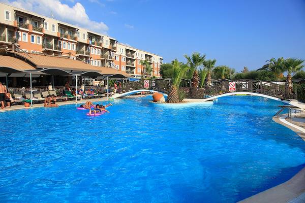 Ein großer Swimmingpool im Club Yali Hotels & Resort mit Gästen, die sich entspannen.