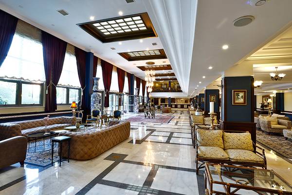 Club Yali Hotels & Resort Lobby mit Sofas, Tischen und Kronleuchtern.