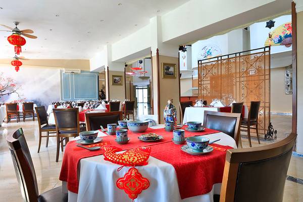 Innenraum des Restaurants im Club Yali Hotels & Resort mit dekorierten Tischen.