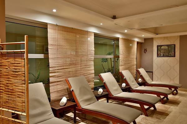 Relaxationsbereich im Club Yali Hotels & Resort mit mehreren Liegen und Bambusvorhängen.