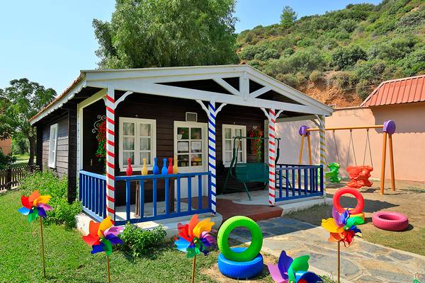 Ein kleines Haus mit bunten Spielgeräten vor dem Club Yali Hotels & Resort.