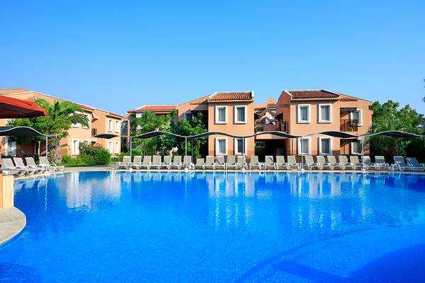 Der Swimmingpool des Club Yali Hotels & Resorts mit Liegestühlen und Sonnenschirmen.
