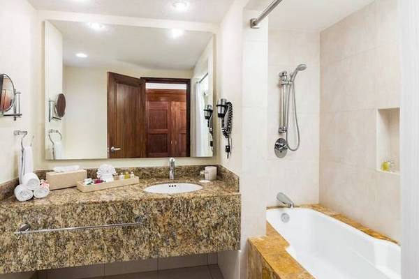 Badezimmer im BlueBay Grand Esmeralda Hotel mit Badewanne, Dusche und Waschbecken.
