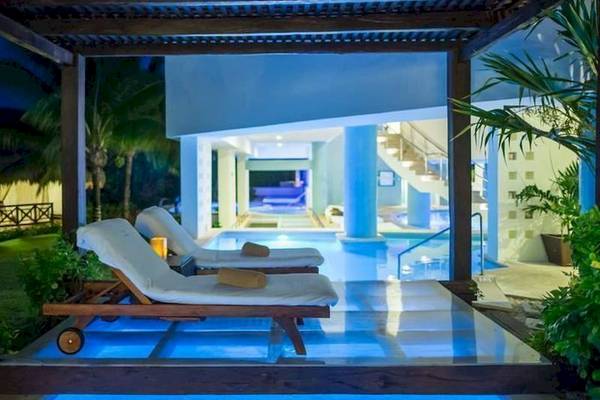 Pool-Lounge-Bereich im BlueBay Grand Esmeralda Hotel mit zwei Liegen und blauem Licht.