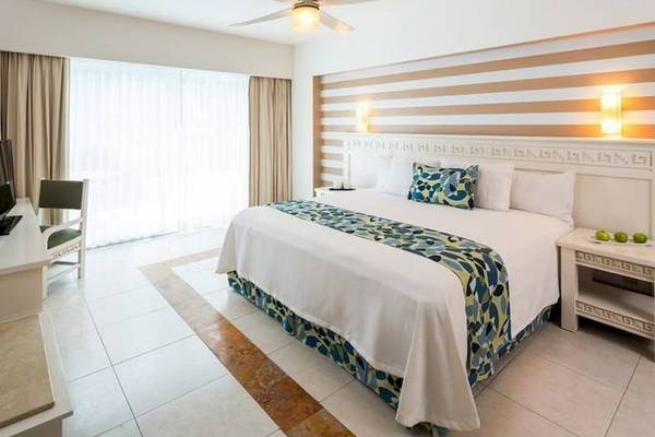 Ein modernes Hotelzimmer im BlueBay Grand Esmeralda mit Bett, Schreibtisch und Klimaanlage.