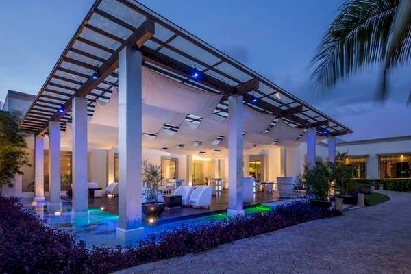 Der Außenbereich des BlueBay Grand Esmeralda Hotels bei Nacht mit Beleuchtung und Wasserfeature.