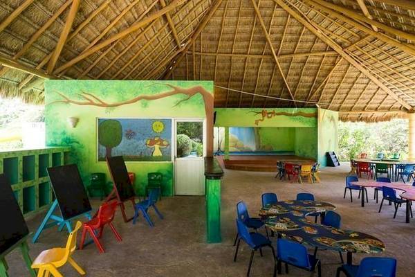 Kinderzimmer im BlueBay Grand Esmeralda Hotel mit bunten Stühlen und Tafeln.