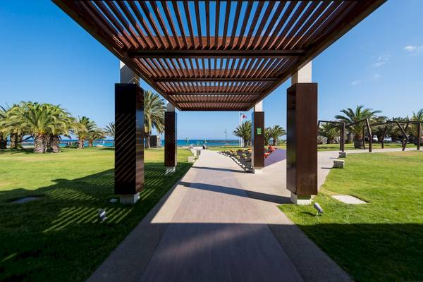 Eingangsbereich des HD Beach Resorts mit überdachtem Weg und Blick auf den Ozean