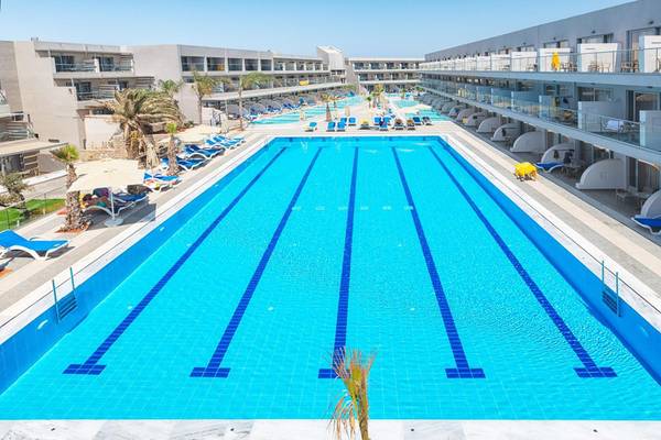 Lyttos Beach Hotel Swimmingpool mit Liegestühlen und Palmen