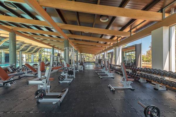 Fitnesscenter im Lyttos Beach Hotel mit vielen Trainingsgeräten und Hanteln.