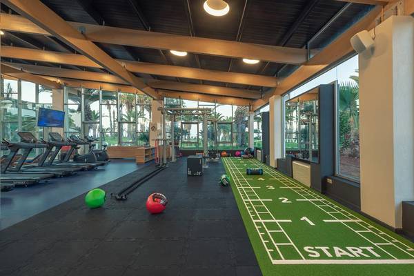 Fitnessbereich im Lyttos Beach Hotel mit Geräten und Trainingsmatte.