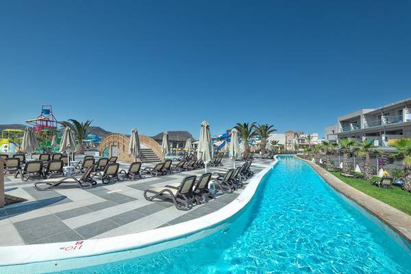 Poolbereich des Lyttos Beach Hotels mit Liegestühlen und Sonnenschirmen