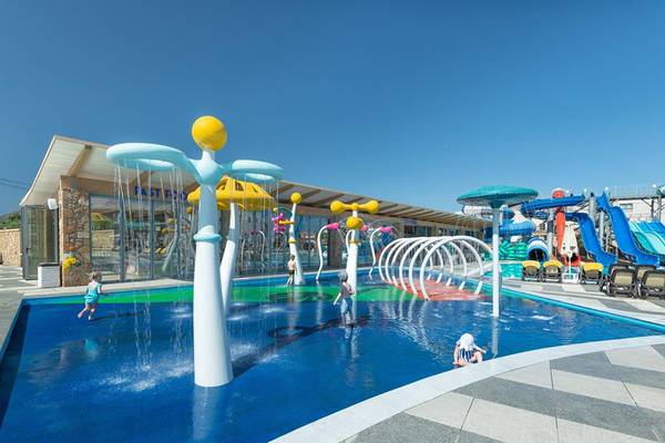 Wasserspielplatz im Lyttos Beach Hotel mit bunten Wassersprudlern und Rutschen.