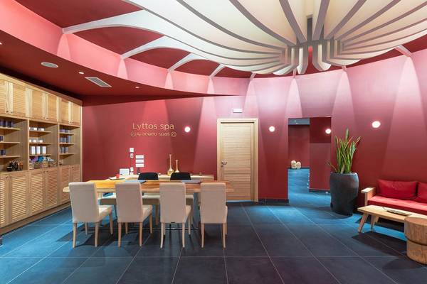 Innenraum des Lyttos Beach Hotel Spa mit roten Wänden, Holzmöbeln und einer modernen Einrichtung.