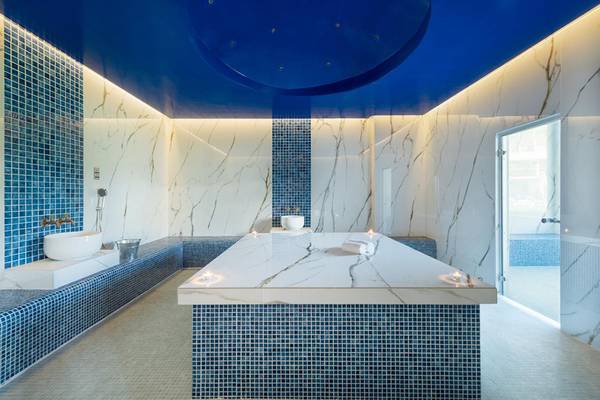 Spa-Bereich des Lyttos Beach Hotels mit blauen Fliesen und Marmorwänden.