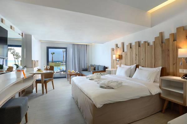 Luxuriöses Hotelzimmer im Lyttos Beach Hotel mit Blick auf den Pool und die Terrasse.