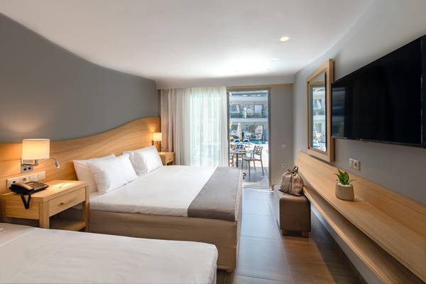 Doppelzimmer im Lyttos Beach Hotel mit zwei Betten, Fernseher und Blick auf den Pool