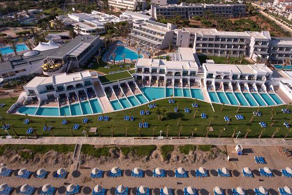 Luftaufnahme des Lyttos Beach Hotels mit mehreren Swimmingpools, Sonnenliegen und Gebäuden.