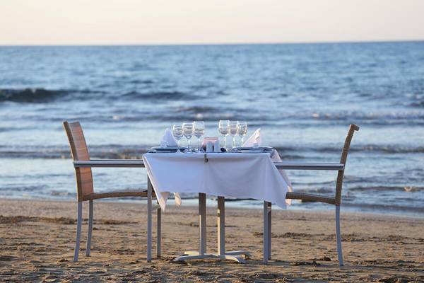Bestuhlter Tisch am Strand mit Aussicht auf das Meer im Lyttos Beach Hotel.