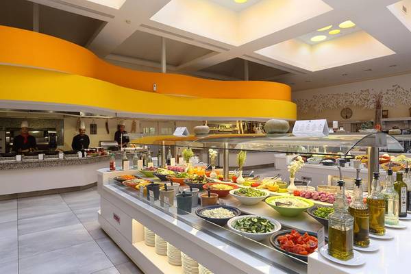 Buffetbereich im Lyttos Beach Hotel mit verschiedenen Salaten und Gemüse, serviert von Köchen.