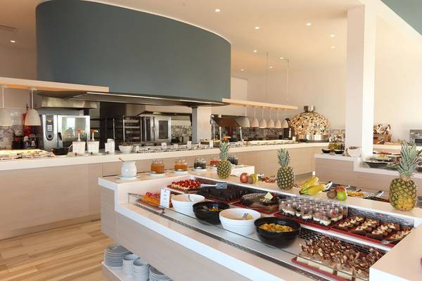 Frühstücksbuffet im Lyttos Beach Hotel mit Obst, Kuchen und Getränken.
