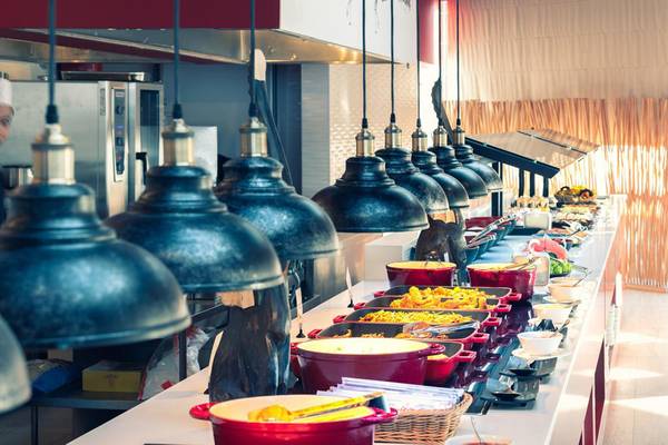Buffet-Tisch im Lyttos Beach Hotel mit verschiedenen Gerichten und Speisen in roten Töpfen.