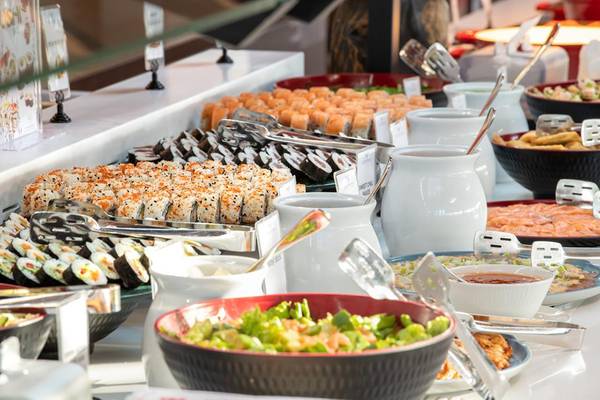 Ein Buffet mit verschiedenen Sushi-Variationen und Salaten in einem Hotel.