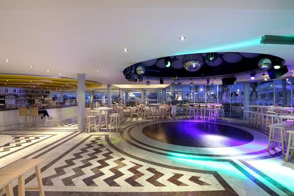 Innenbereich des Lyttos Beach Hotels mit Bar, Tischen und Disco-Bereich.