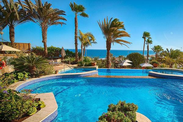 Außenpool des Corallium Dunamar Garden Hotels mit Blick auf das Meer und Palmen
