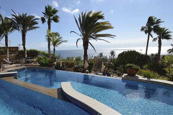 Außenpool im Corallium Dunamar Garden Hotel mit Blick auf das Meer und Palmen