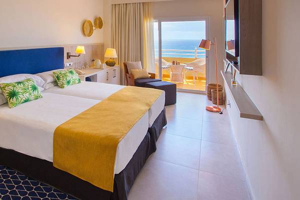 Doppelzimmer mit Meerblick im Corallium Dunamar Garden Hotel mit zwei Betten, Balkon und Fernseher.
