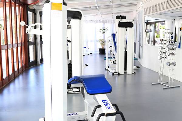 Innenansicht des Fitnesscenters im Corallium Dunamar Garden by Lopesan Hotels mit Geräten und Pflanzen.