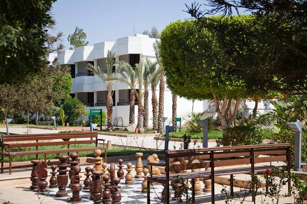 Außenbereich des Ghazala Beach Hotels mit einem Schachspiel und Bänken.