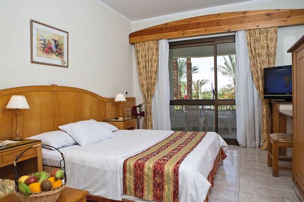 Hotelzimmer im Ghazala Beach mit Bett, Obstkorb und Balkonzugang.