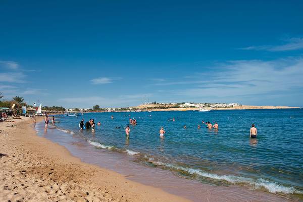Viele Menschen schwimmen und entspannen sich am Strand des Ghazala Beach Hotels