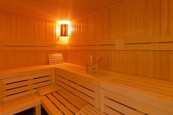 Saunabereich im Princess Andriana Resort & Spa mit warmem Licht und Holzbänken.